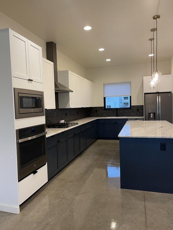 Kitchen with dark cabinetry and a marble island