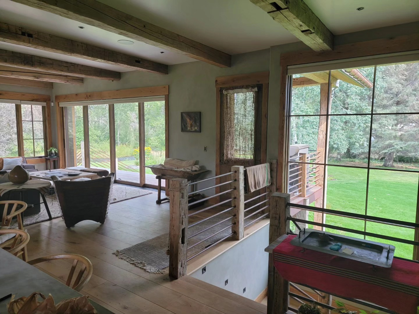Timber-frame living room opening onto a lawn through sliding glass doors